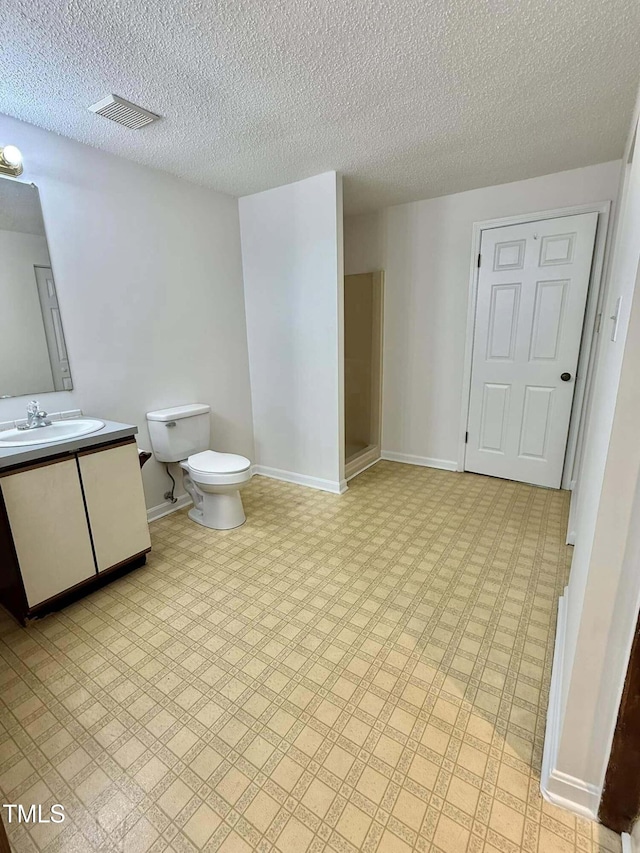 bathroom featuring vanity, a textured ceiling, visible vents, and toilet