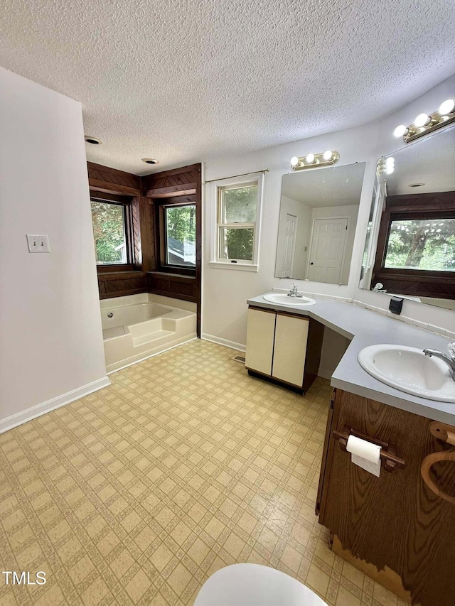 full bath featuring double vanity, a sink, and a bath