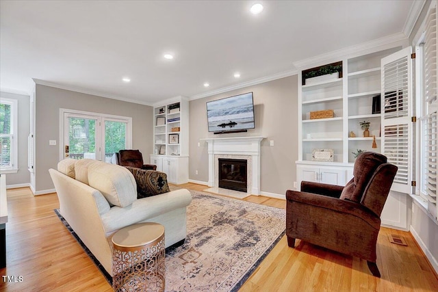 105 Wittenham Dr, Cary, NC 27519 - living area featuring light wood-style flooring, ornamental molding, a fireplace, recessed lighting, and baseboards