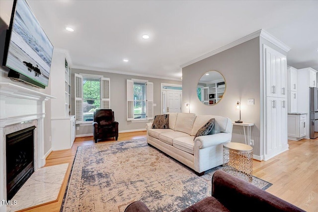 105 Wittenham Dr, Cary, NC 27519 - living area featuring light wood-style flooring, ornamental molding, baseboards, a high end fireplace, and recessed lighting