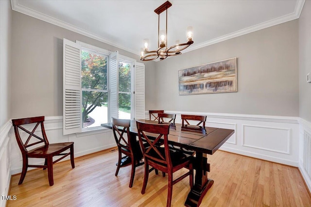 105 Wittenham Dr, Cary, NC 27519 - dining area with a chandelier, crown molding, light wood-type flooring, and wainscoting