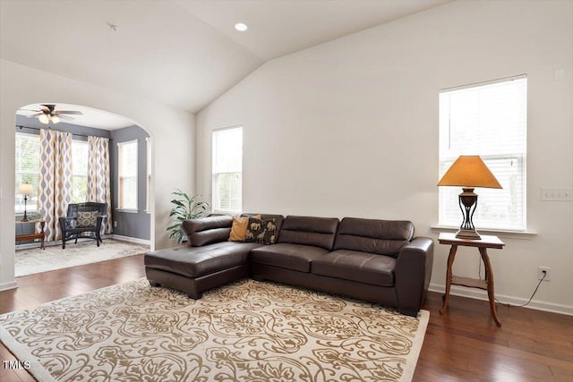living area with baseboards, a healthy amount of sunlight, and wood finished floors