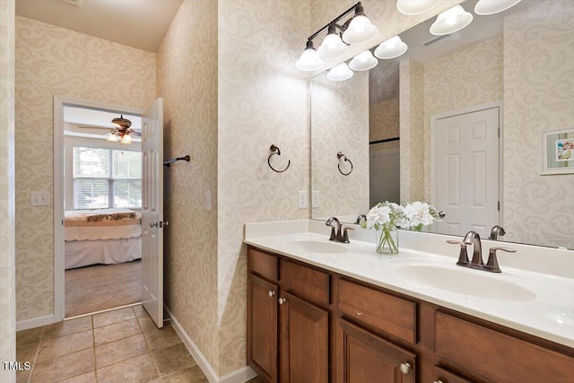 bathroom with double vanity, baseboards, ceiling fan, and a sink