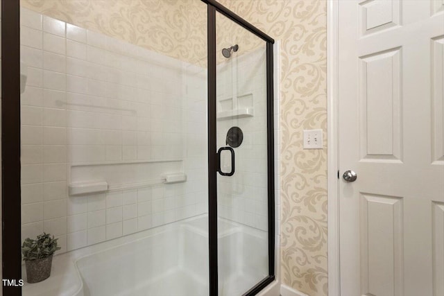 bathroom featuring wallpapered walls and a stall shower