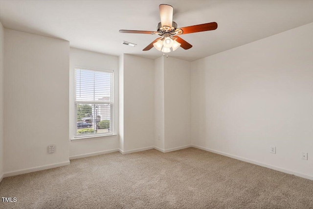unfurnished room with baseboards, ceiling fan, carpet flooring, and visible vents