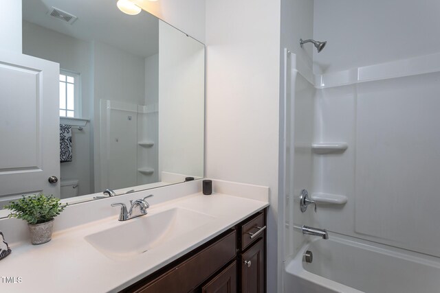 full bath with toilet, visible vents, washtub / shower combination, and vanity