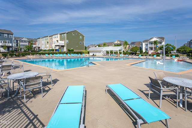 pool with a patio, a pergola, and a residential view