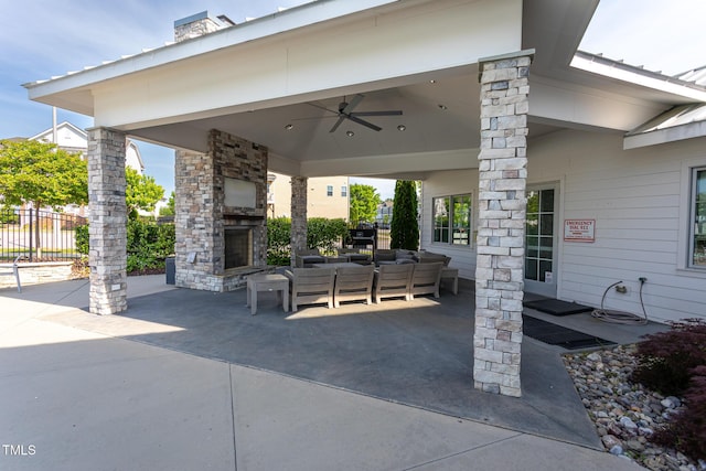 view of patio with fence, a ceiling fan, and an outdoor living space with a fireplace