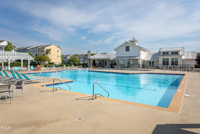 pool featuring a pergola, fence, and a patio area