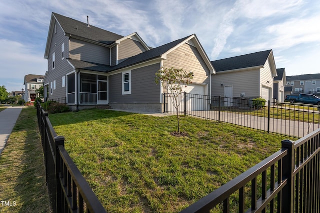 view of side of property featuring a sunroom, concrete driveway, an attached garage, a yard, and a residential view