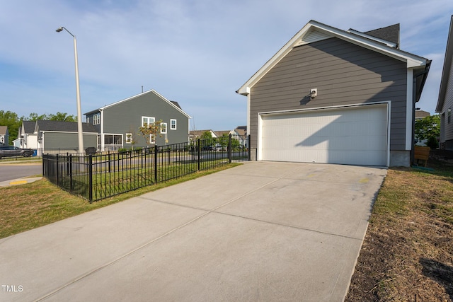 view of home's exterior with a yard, fence, and a garage