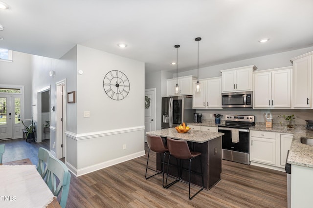 180 Long Grass Dr, Smithfield, NC 27577 - kitchen featuring a kitchen breakfast bar, appliances with stainless steel finishes, a center island, dark wood finished floors, and white cabinets