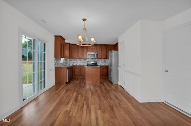 kitchen with tasteful backsplash, light countertops, dark wood-style floors, an inviting chandelier, and stainless steel appliances