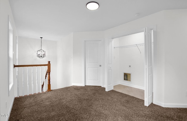 interior space featuring baseboards, a notable chandelier, and dark colored carpet