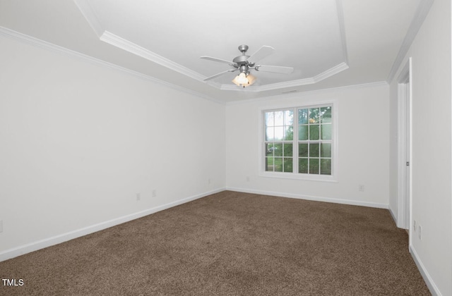 empty room featuring a raised ceiling, baseboards, dark carpet, and ceiling fan