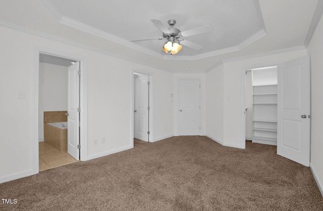 unfurnished bedroom featuring crown molding, baseboards, carpet, and a spacious closet