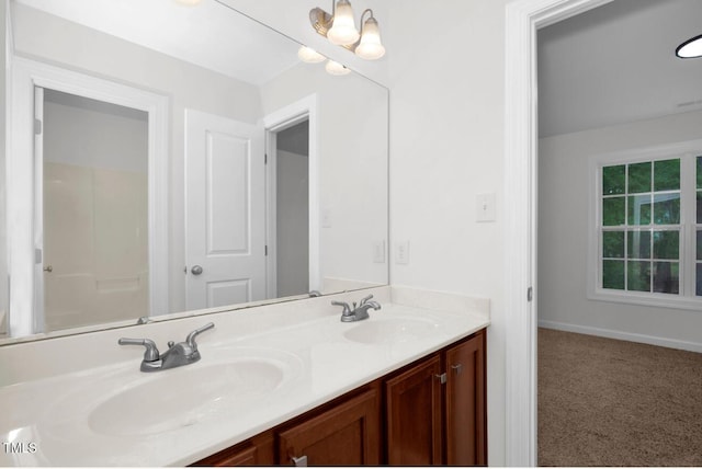 full bathroom with double vanity, a sink, and baseboards
