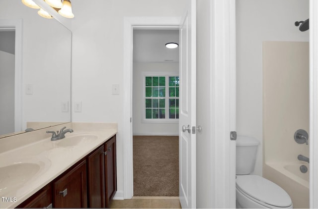 full bath with double vanity, toilet, and a sink
