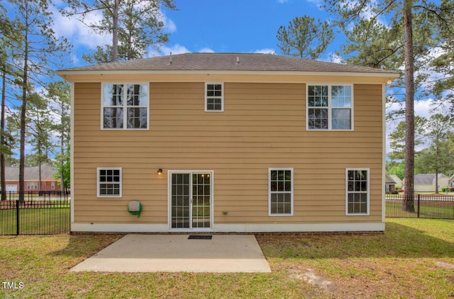 rear view of house featuring a lawn, fence, and a patio area