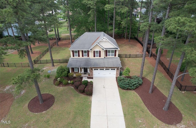 traditional home with a garage, concrete driveway, brick siding, and a front yard