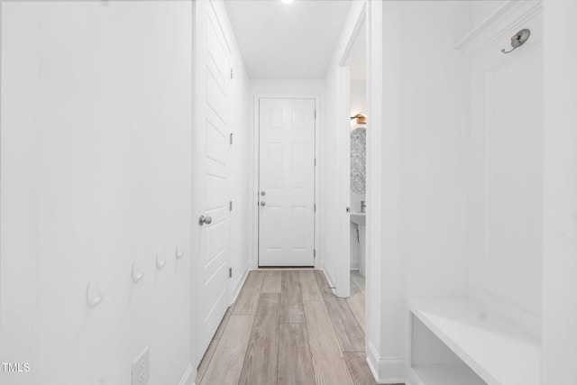 hallway featuring light wood-style floors and baseboards