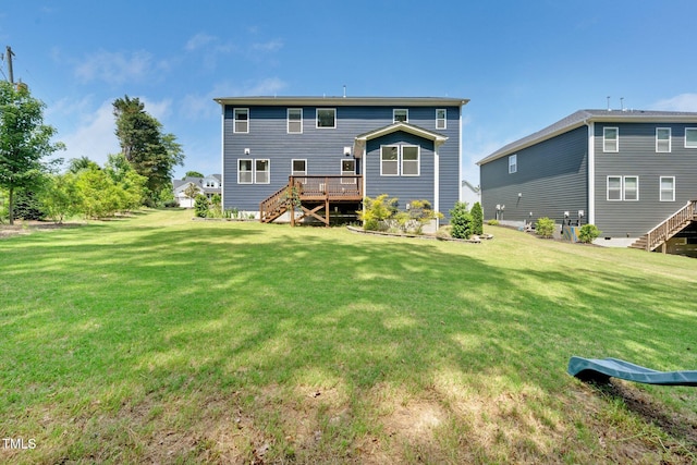 back of house featuring a lawn, a wooden deck, and stairway