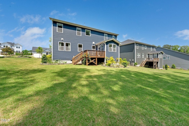 rear view of house with a lawn, stairway, and a deck