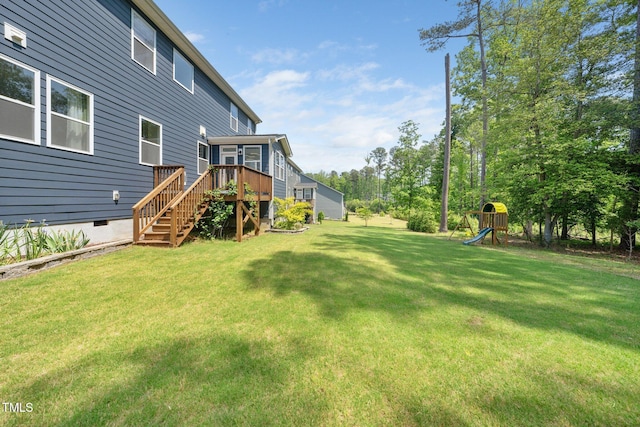 view of yard featuring stairs, a playground, and a deck