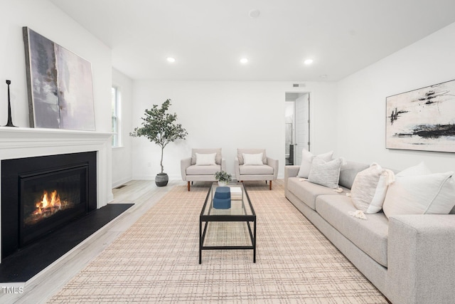 1813 Lost Creek Ct, Apex, NC 27539 - living room with light wood-style flooring, a glass covered fireplace, recessed lighting, and baseboards