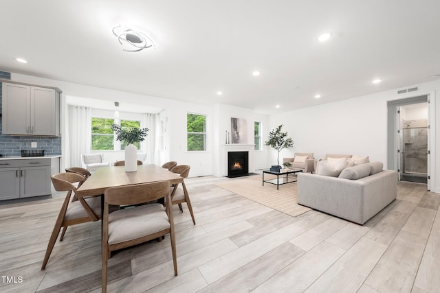 1813 Lost Creek Ct, Apex, NC 27539 - dining area featuring light wood-style floors, a lit fireplace, and recessed lighting