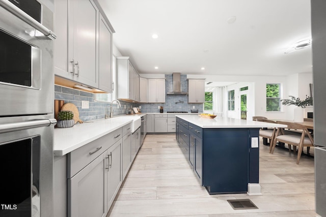 1813 Lost Creek Ct, Apex, NC 27539 - kitchen with wall chimney range hood, double oven, backsplash, light countertops, and a center island