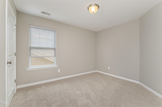 carpeted spare room with visible vents and baseboards