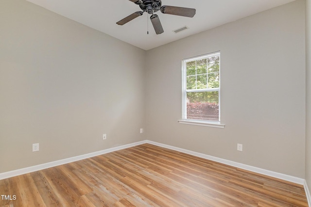 empty room with baseboards, light wood finished floors, and visible vents