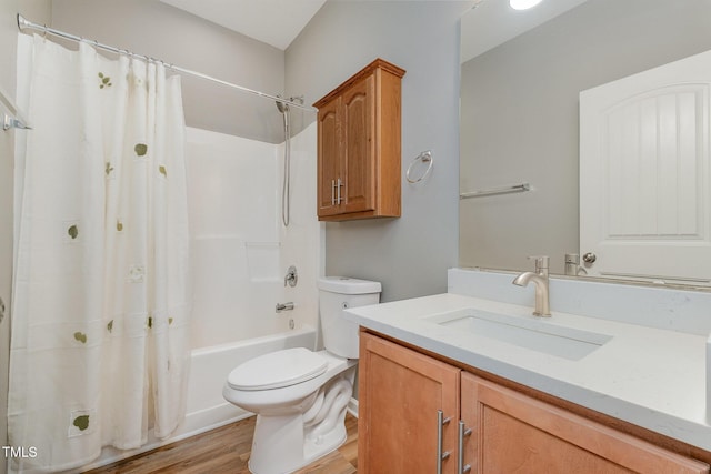 bathroom with toilet, wood finished floors, shower / tub combo, and vanity