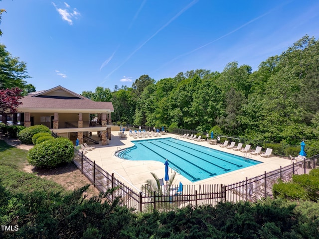 pool with a patio and fence