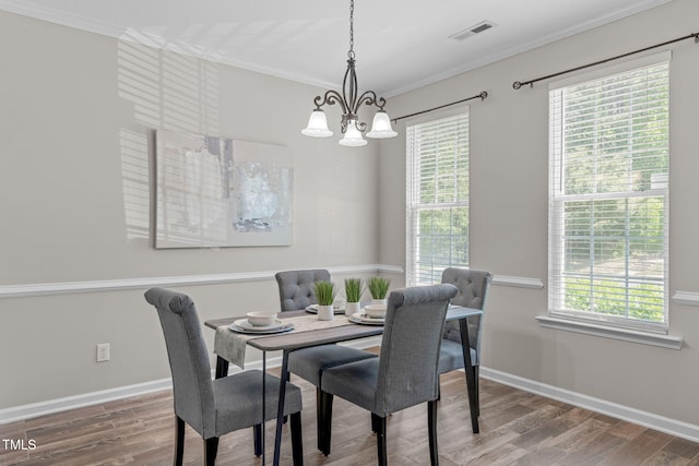 dining space featuring a notable chandelier, visible vents, a healthy amount of sunlight, and wood finished floors