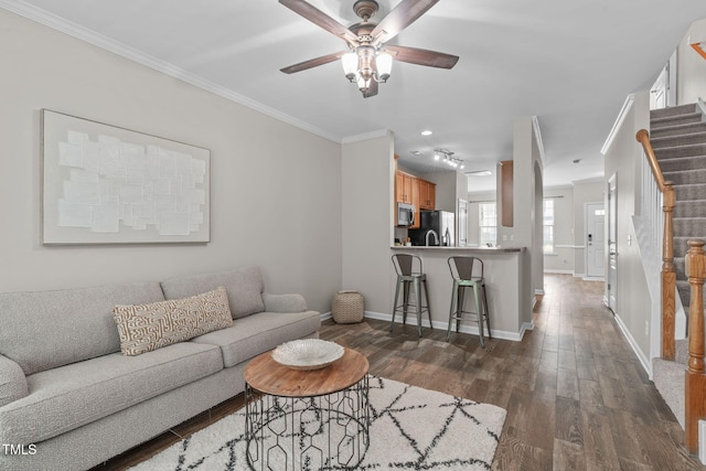living room with dark wood-style flooring, stairs, a ceiling fan, baseboards, and ornamental molding