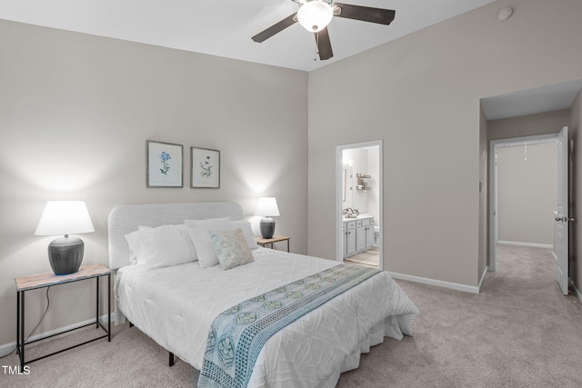 bedroom with carpet flooring, a ceiling fan, baseboards, and ensuite bath