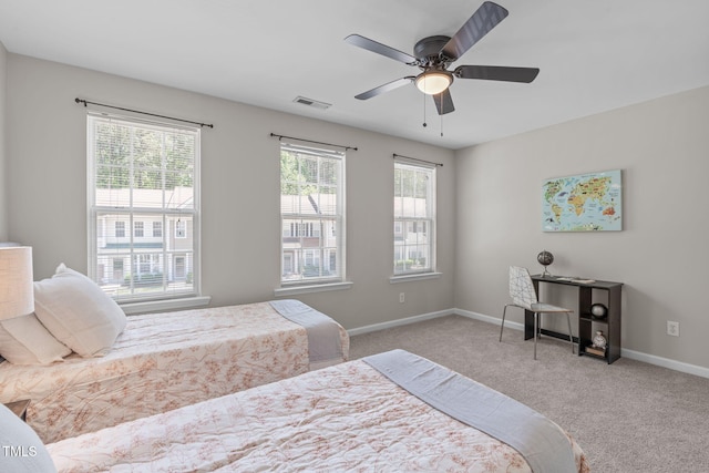 carpeted bedroom with visible vents, baseboards, and ceiling fan