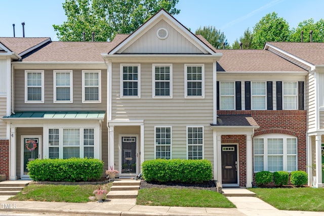 multi unit property with brick siding, board and batten siding, and roof with shingles
