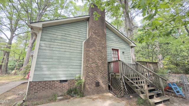view of side of home with a chimney and crawl space