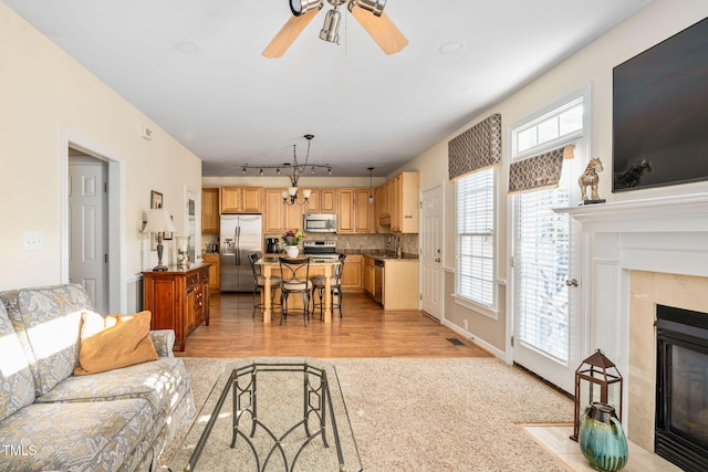 210 Presidents Walk Ln, Cary, NC 27519 - living area with visible vents, a fireplace, light carpet, ceiling fan, and light wood-type flooring