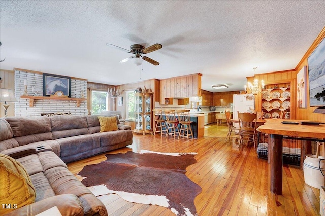 206 Kittys Ln, Erwin, NC 28339 - living area featuring wooden walls, a textured ceiling, ceiling fan with notable chandelier, and light wood-type flooring