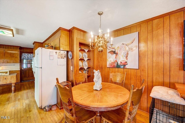 206 Kittys Ln, Erwin, NC 28339 - dining room featuring crown molding, light wood finished floors, a notable chandelier, and wooden walls