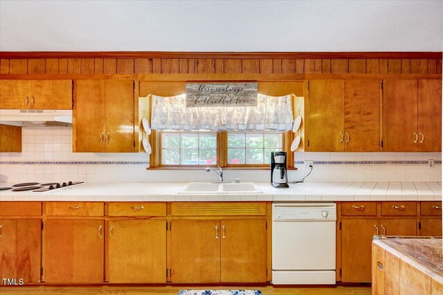 206 Kittys Ln, Erwin, NC 28339 - kitchen featuring backsplash, brown cabinets, a sink, under cabinet range hood, and white appliances