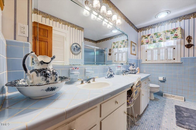 206 Kittys Ln, Erwin, NC 28339 - bathroom featuring a sink, double vanity, wallpapered walls, tile walls, and a stall shower