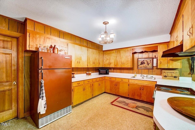 206 Kittys Ln, Erwin, NC 28339 - kitchen with a textured ceiling, light countertops, freestanding refrigerator, a notable chandelier, and wooden walls
