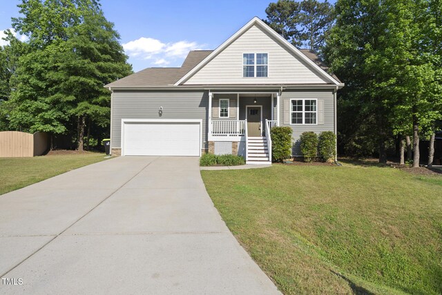 20 Paddy Ln, Youngsville, NC 27596 - view of front of property featuring concrete driveway, a front lawn, covered porch, and a garage