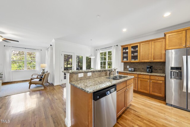 20 Paddy Ln, Youngsville, NC 27596 - kitchen featuring stainless steel appliances, brown cabinetry, a sink, plenty of natural light, and crown molding