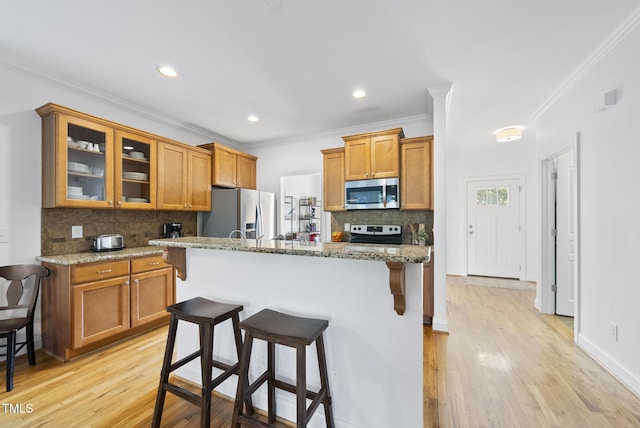 20 Paddy Ln, Youngsville, NC 27596 - kitchen with stainless steel appliances, a breakfast bar, ornamental molding, tasteful backsplash, and brown cabinets